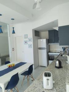 uma cozinha com armários azuis e um balcão branco em Elegante Duplex Oceanico da Elena Super Cozinha USP y UfSCAR em São Carlos