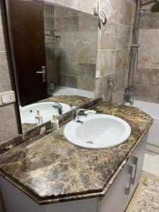 a bathroom with a sink and a mirror and a tub at Room in new Cairo near the airport in Cairo