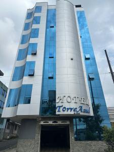 un edificio con un cartel en el costado en Hotel Torre Azul en Santo Domingo de los Colorados