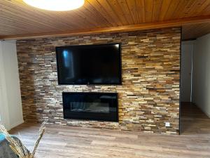 a fireplace with a tv on a brick wall at SNOW NEST: Superbe cocon enneigé in Crans-Montana