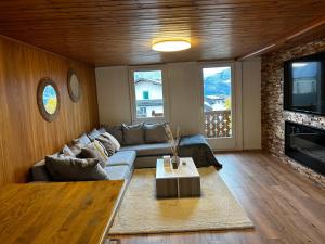 a living room with a couch and a tv at SNOW NEST: Superbe cocon enneigé in Crans-Montana