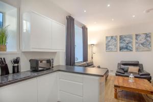 uma cozinha com um micro-ondas e uma sala de estar em Selkies Retreat ✪ Grampian Lettings Ltd em Aberdeen