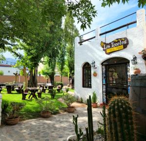 un restaurant avec une terrasse meublée de tables et de cactus dans l'établissement Cafayate los toneles, à Cafayate