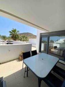 a white table and chairs on a balcony with a view at Villa Hélice - Moderno apartamento en Cabo de Gata in Las Negras