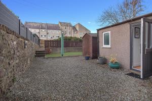 a backyard with a building and a fence and a yard at Selkies Retreat ✪ Grampian Lettings Ltd in Aberdeen