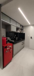 eine Küche mit einem roten Kühlschrank im Zimmer in der Unterkunft Unity Garden 08 com Jacuzzi Privativa in João Pessoa