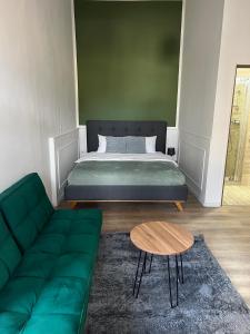 a bedroom with a bed and a couch and a table at Homeland Center Cluj in Cluj-Napoca