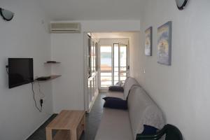 een woonkamer met een bank en een tv bij Apartment Vidakovic in Budva