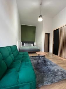 a living room with a green couch and a bed at Homeland Center Cluj in Cluj-Napoca
