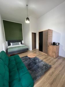 - une chambre avec un lit et un canapé vert dans l'établissement Homeland Center Cluj, à Cluj-Napoca