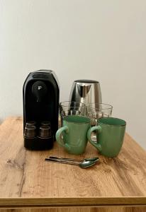 a coffee maker and two cups on a wooden table at Homeland Center Cluj in Cluj-Napoca +12 photos