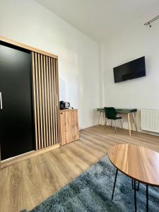 a living room with a table and a tv at Homeland Center Cluj in Cluj-Napoca