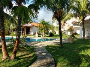 a resort with a swimming pool and palm trees at Villa Cocuyo - Studios & Apartments in El Cardón
