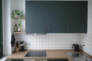 een keuken met blauwe kasten en een wastafel bij NEU! Uni-Nähe! Altbau Apartment, Küche, TV, Balkon in Maagdenburg