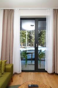 a living room with a sliding glass door with a table at Bjelasnica A6 in Bjelašnica