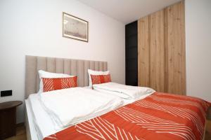 a bedroom with a bed with orange and white sheets at Bjelasnica A6 in Bjelašnica +11 photos