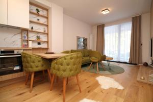 a living room with a couch and a table and chairs at Bjelasnica A6 in Bjelašnica