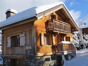 a wooden cabin with a balcony in the snow at Chalet rénové 3 chambres, proche centre Courchevel - FR-1-514-25 in le Praz