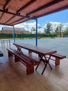 a large wooden picnic table on a tennis court at Alojamiento Los Imigrantes in Chajarí