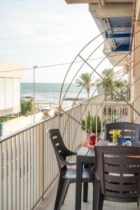 einen Balkon mit Tisch und Stühlen sowie Strand in der Unterkunft CapoSud - Appartamento Salgari in Marina di Ragusa