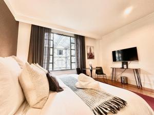 a bedroom with a large bed with a large window at Charming Studio Apartment in Auckland Central in Auckland