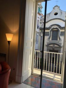 une porte donnant sur un balcon avec vue sur un bâtiment dans l'établissement Casa Orlanda, à Naples