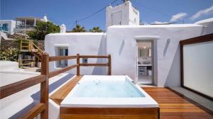 a hot tub on the balcony of a house at Legacy Suites in Mýkonos City