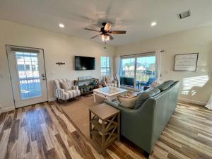 a living room with a couch and a ceiling fan at Family Tides on LGI - Golf Cart Included in Placida