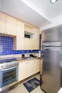 uma cozinha com armários brancos e um frigorífico de aço inoxidável em Beira-Mar maravilhoso! Ideal para nômades digitais! em Salvador