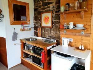 a small kitchen with a sink and a stove at The Studio at Stoodley Pike View in Todmorden