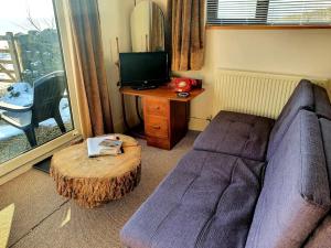 a living room with a couch and a table and a tv at The Studio at Stoodley Pike View in Todmorden