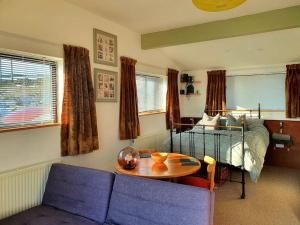 Habitación con sofá, mesa y cama en The Studio at Stoodley Pike View, en Todmorden