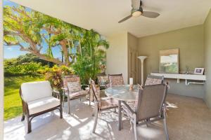 un comedor con mesa, sillas y una pintura en Hilton Pool Pass Included - Luxe Villa, en Waikoloa