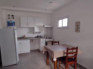 a kitchen with a table and a white refrigerator at DTo CÉNTRICO LOBOS 1 C in Lobos