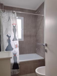 ein Bad mit einem Duschvorhang mit Kleidern darauf in der Unterkunft DTo CÉNTRICO LOBOS 1 C in Lobos