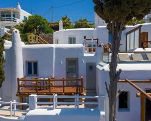 un banc en bois assis sur le côté du bâtiment dans l'établissement Legacy Suites, à Mykonos