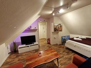 1 dormitorio con 1 cama, TV y mesa en Smaller apartment next to bridge, en Tromsø