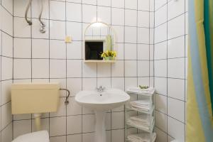 a white bathroom with a sink and a mirror at Apartments Nada in Bol