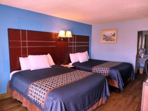 a hotel room with two beds with blue walls at Rodeway Inn in Richland