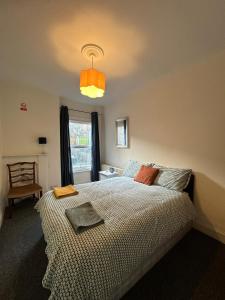 a bedroom with a large bed and a lamp at Luton Town House Near AIRPORT in Luton