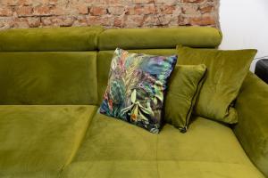 a green couch with a colorful pillow on it at Sweet cozy Ultracentral in Craiova