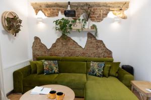 a green couch in a living room with a table at Sweet cozy Ultracentral in Craiova