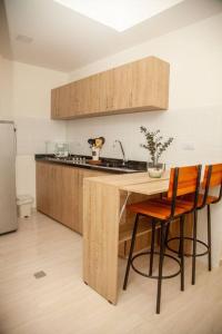 a kitchen with a wooden table and two chairs at Acogedor apartamento moderno para 6 personas in Cali