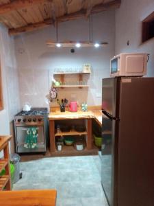 a small kitchen with a stainless steel refrigerator at Anacrusa Hostel in Epuyén