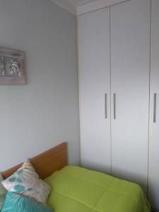 a bedroom with a green bed and two white cabinets at Próximo Parque Aclimação e Região da Paulista in Sao Paulo