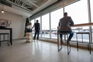 a group of people standing in a room looking out the window at Arch + Cable Hotel in Mankato