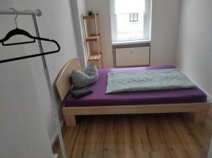 Cama pequeña en habitación con colchón morado en Furnished apartments for employees with separate rooms, en Zeitz