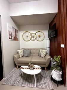 een woonkamer met een bank en een tafel bij New & Spacious Unit in QC w/ Wifi & Netflix in Manilla