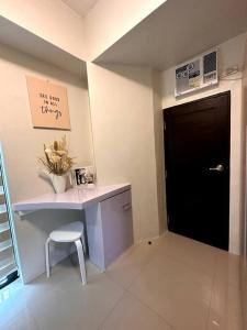 een kamer met een bureau met een stoel en een zwarte deur bij New & Spacious Unit in QC w/ Wifi & Netflix in Manilla
