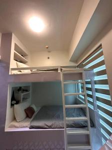 een kamer met 2 stapelbedden en een ladder bij New & Spacious Unit in QC w/ Wifi & Netflix in Manilla